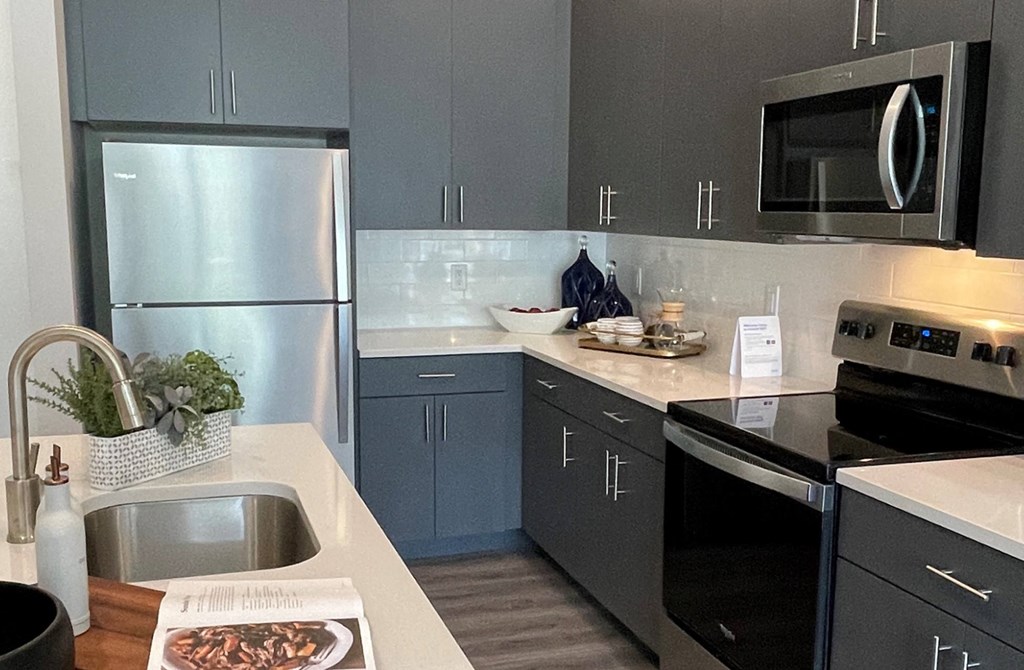 a kitchen with gray cabinets and black and white appliances