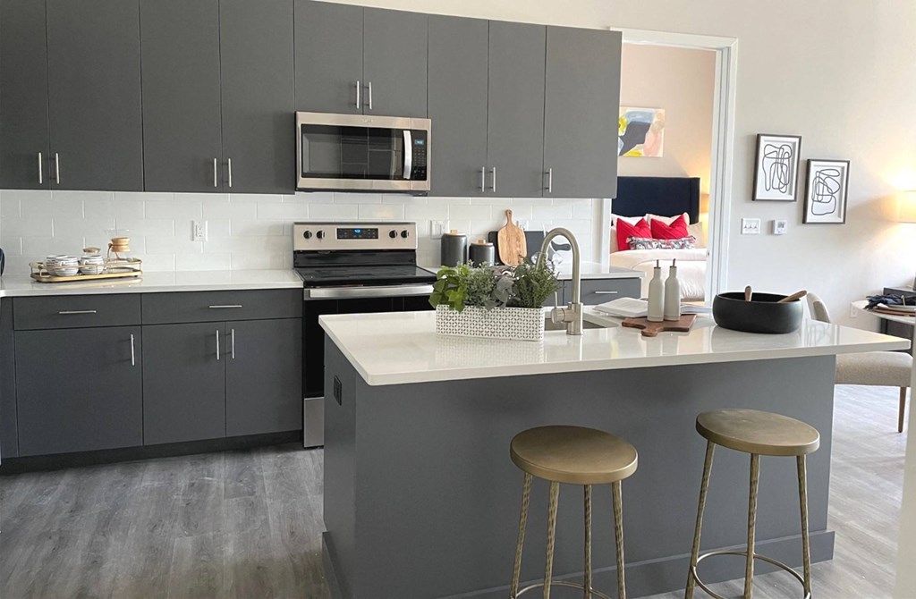 a kitchen with gray cabinets and a white counter top