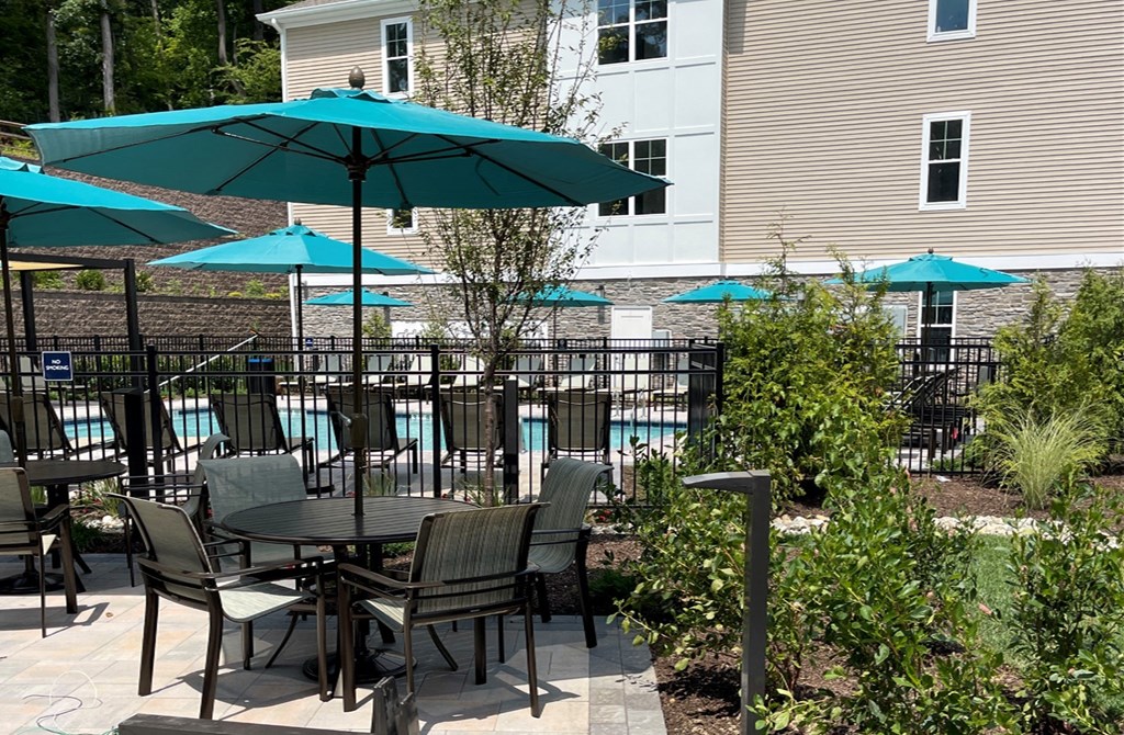 a patio with a table and chairs and umbrellas