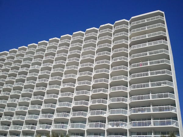 a tall white building with a blue sky in the background