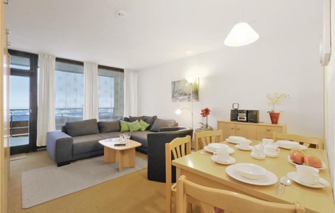 a living room and dining room with a table and chairs