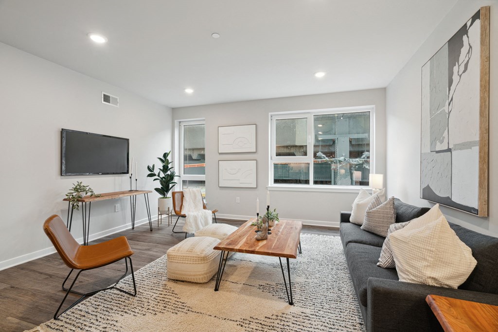 a living room with a gray couch and a tv on the wall