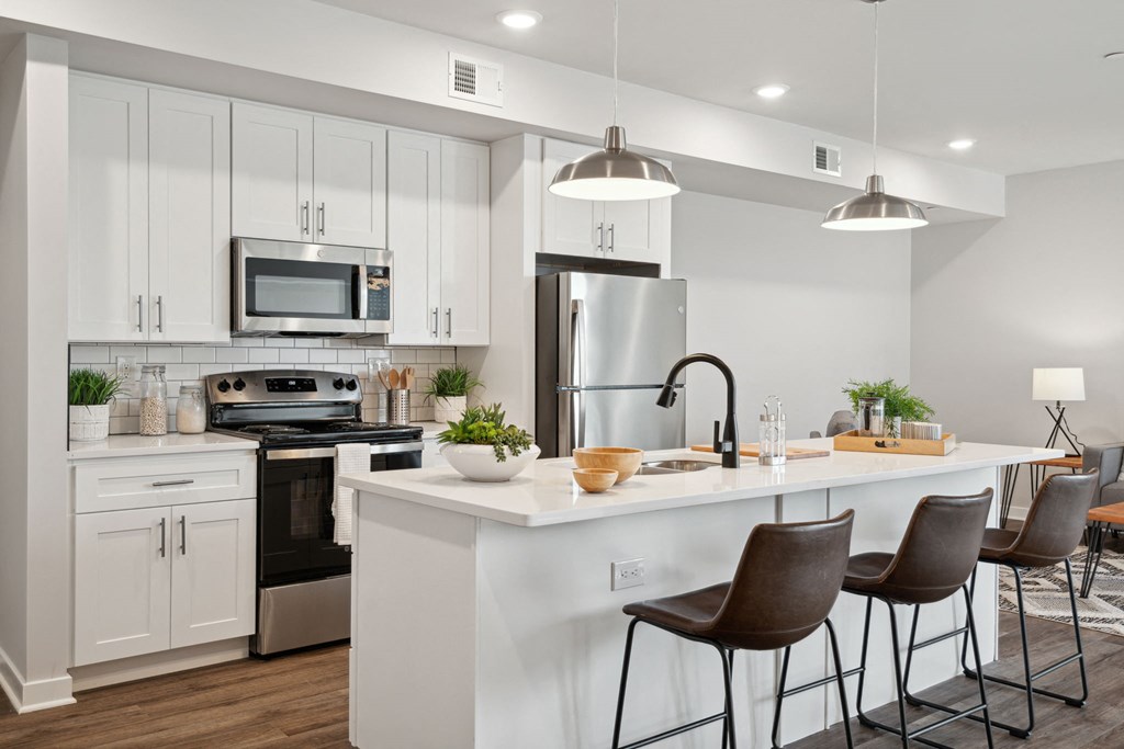 an open kitchen with a large island with stools