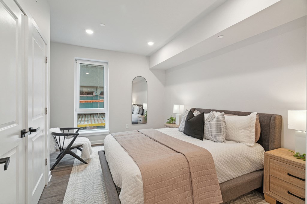 a bedroom with a bed and a chair in a 555 waverly unit