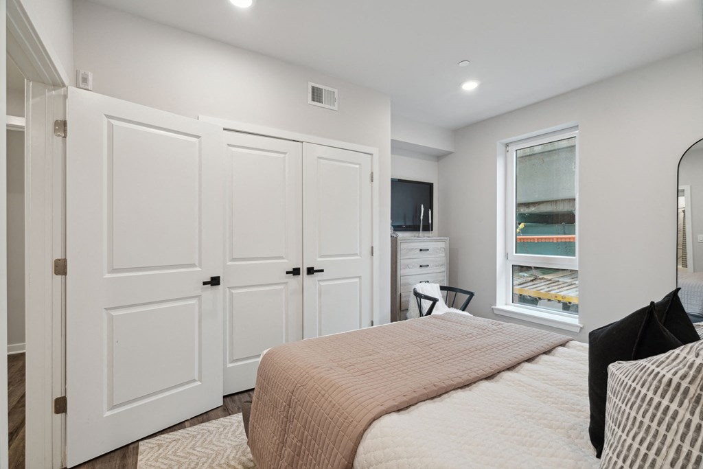 a bedroom with a bed and a window