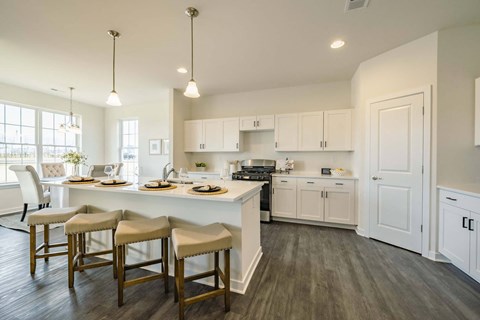 a kitchen and dining room with white cabinets and a table