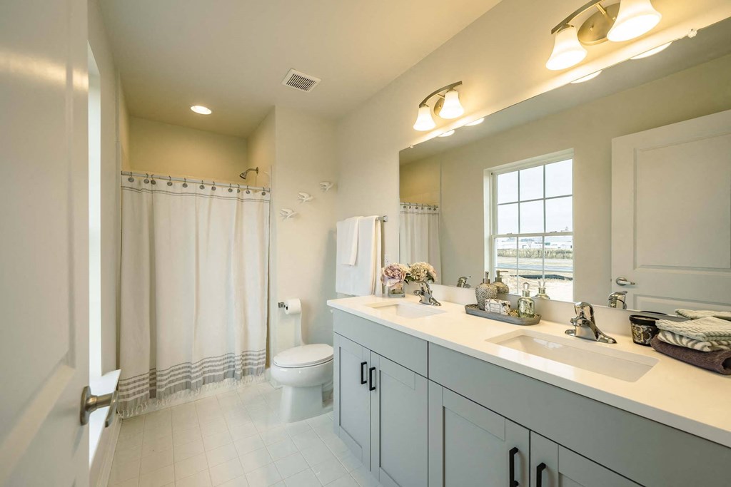 Primary bathroom with double vanity and toilet
