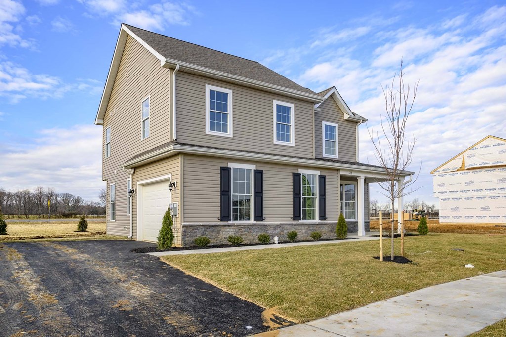 Exterior of tan 2 story cottage with garage
