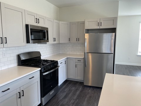 A kitchen with a stove, microwave, and refrigerator.
