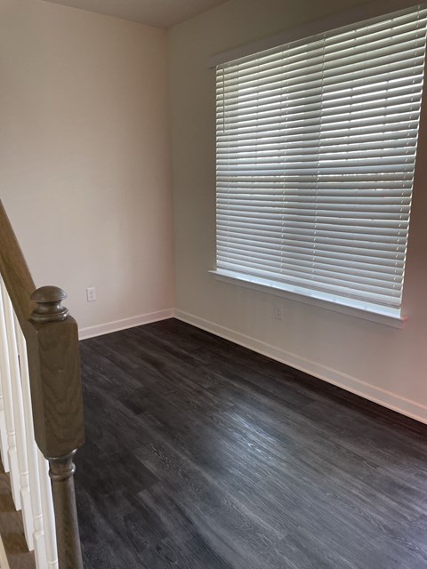 a room with wood floors and a window and a staircase