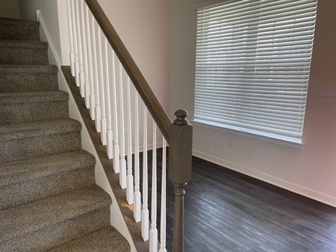 a staircase in a home with a large window and a stairwell with a railing