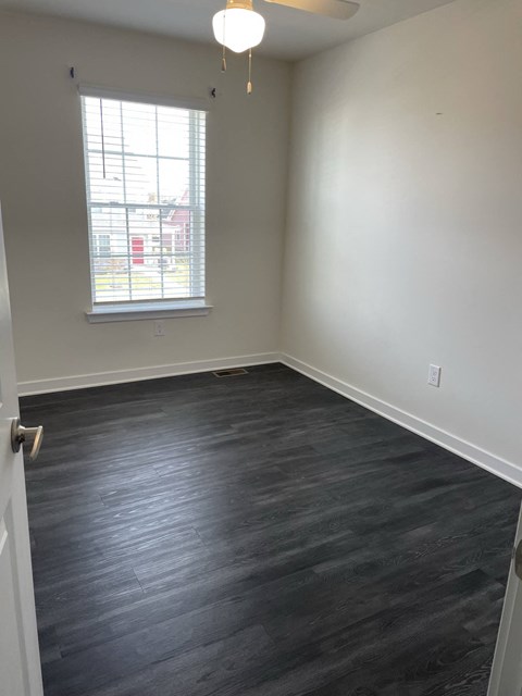 an empty room with wood floors and a window