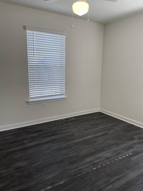 an empty room with wood floors and a window