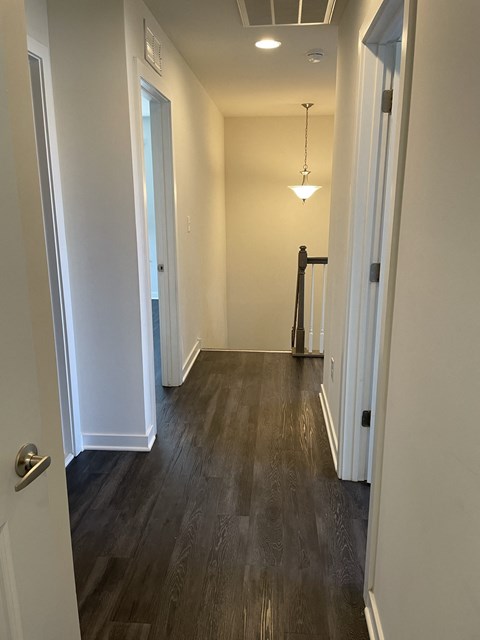 a look down the hallway of a new home with wood flooring