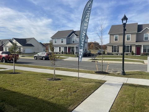 a sidewalk with a sign in the middle of a street
