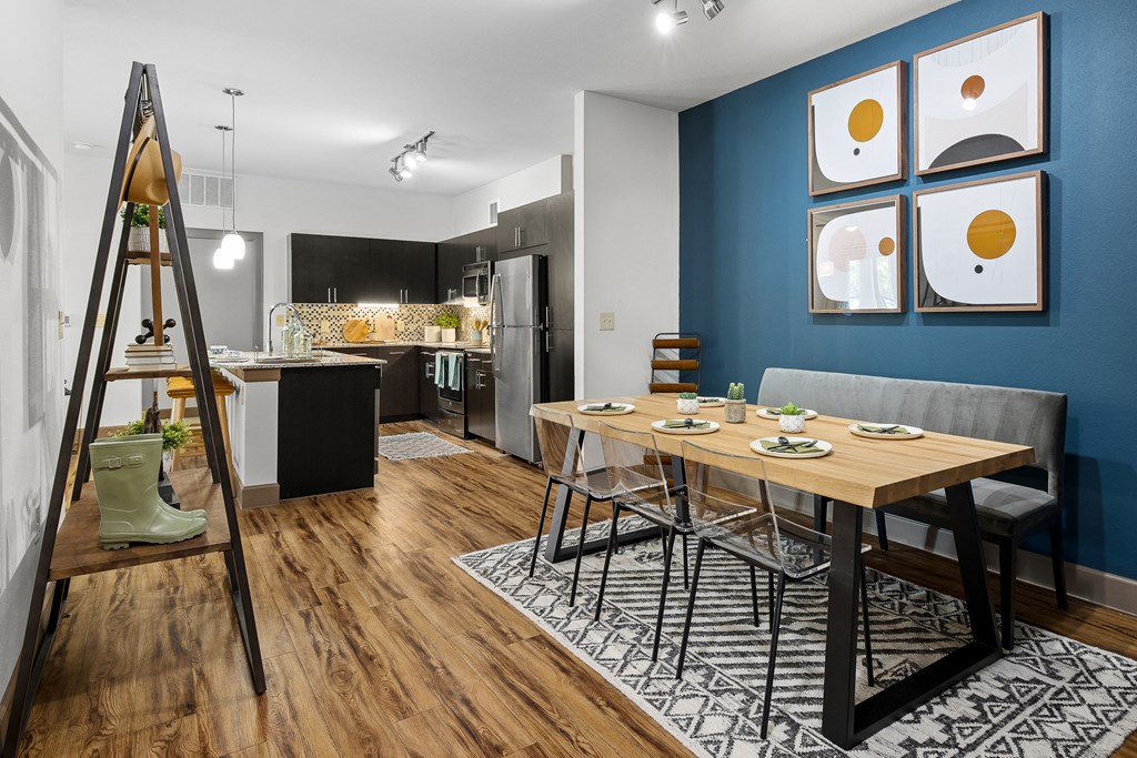 a living room and dining room with a table and a ladder