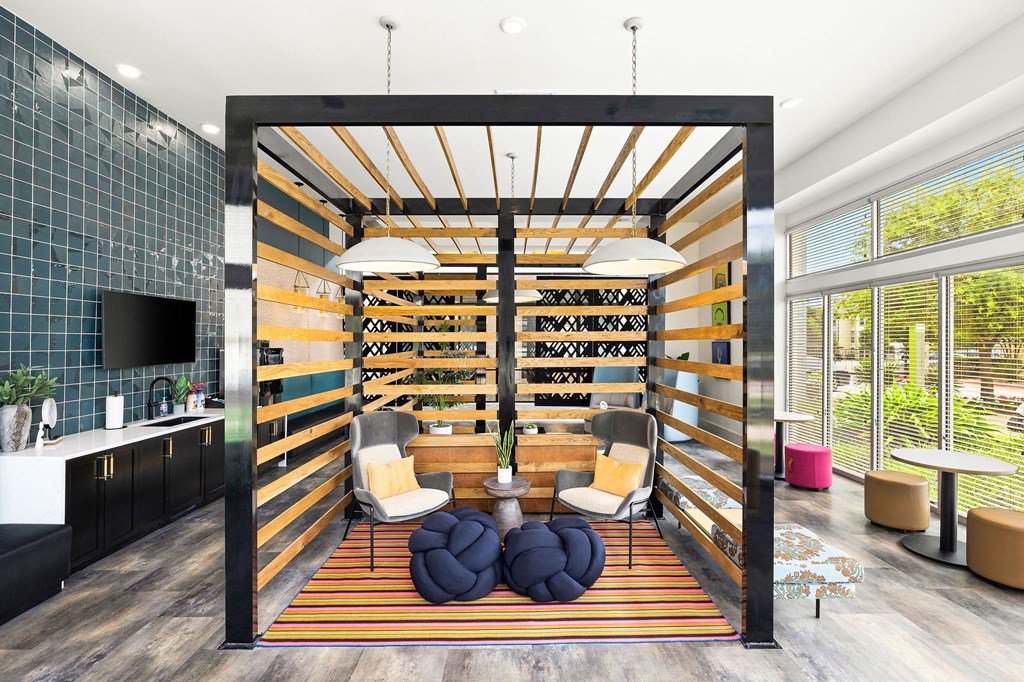 a living room with a wall of wine shelves and a table and chairs