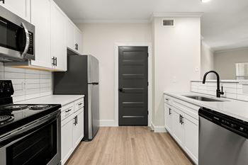 A kitchen with black and white appliances and cabinets.