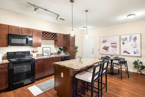 A kitchen with a black stove top oven and black microwave.