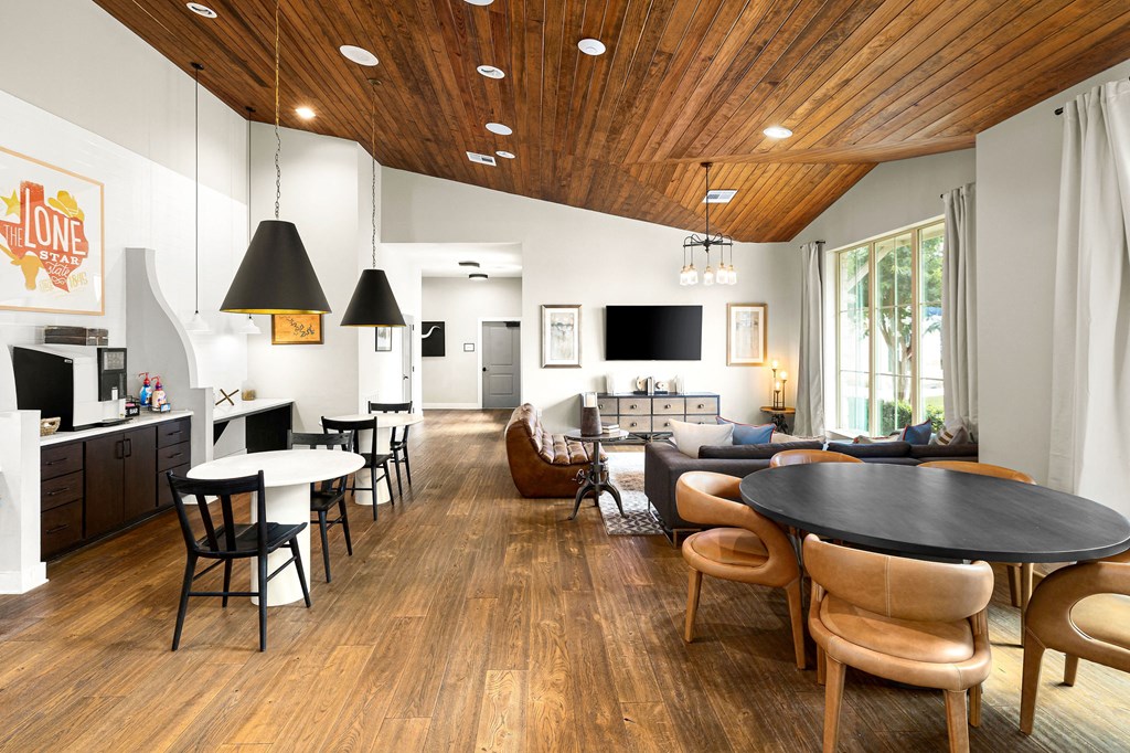 a living room with a table and chairs and a kitchen