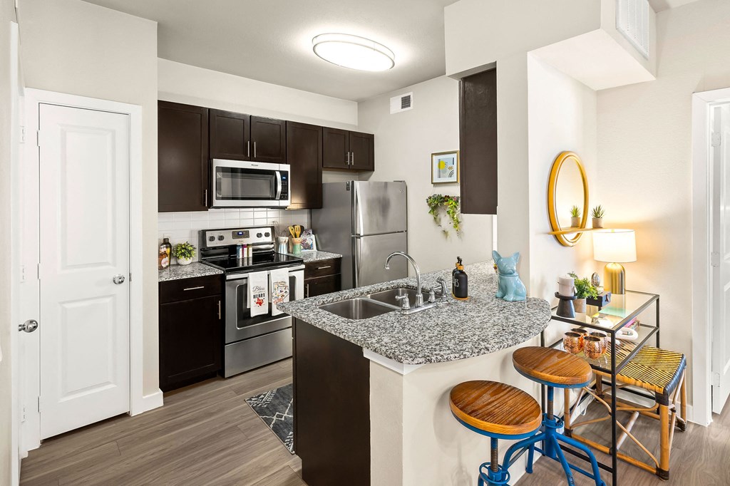 kitchen with stainless steel appliances, granite countertops and pantry. peninsula island bar top eating area.