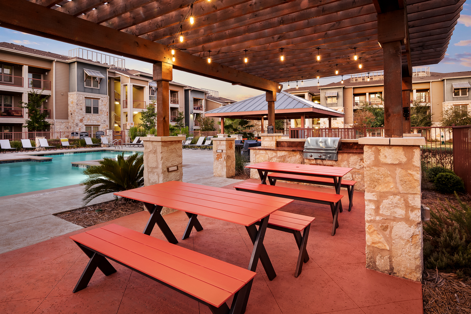 a group of picnic tables sitting next to a swimming pool