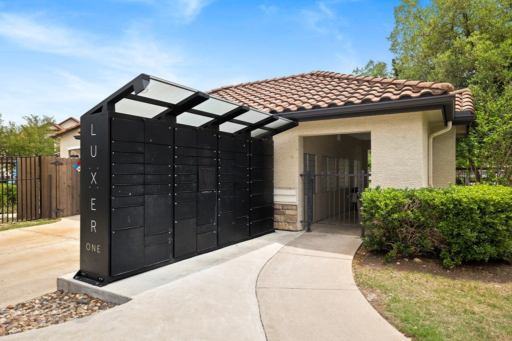 a gate to a house with a driveway and a fence