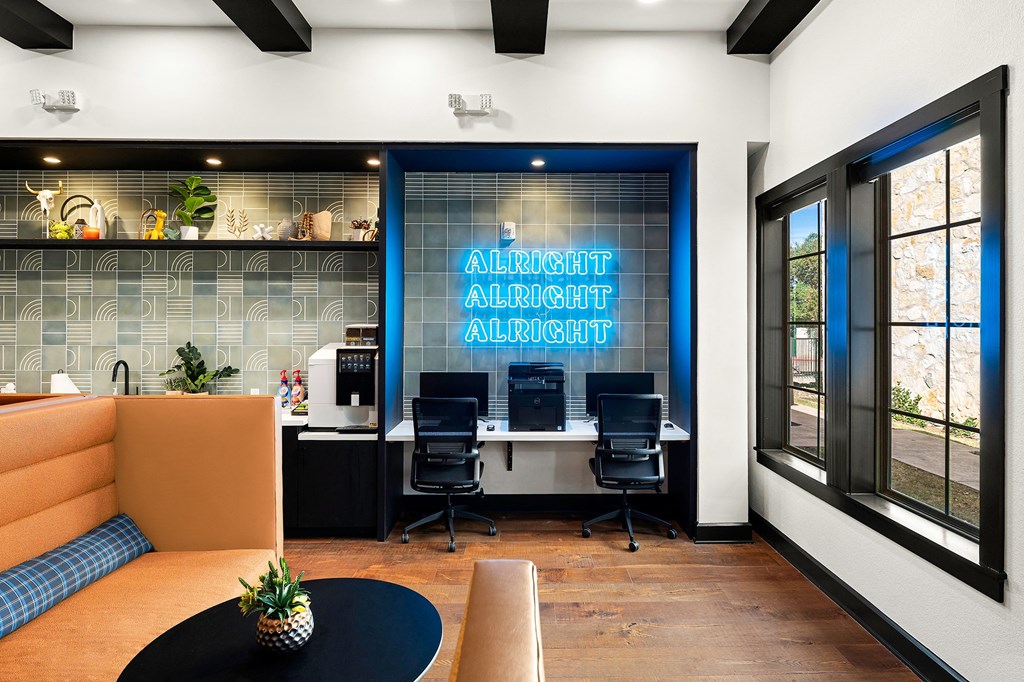 a large office space with a desk and chairs and a blue sign on the wall