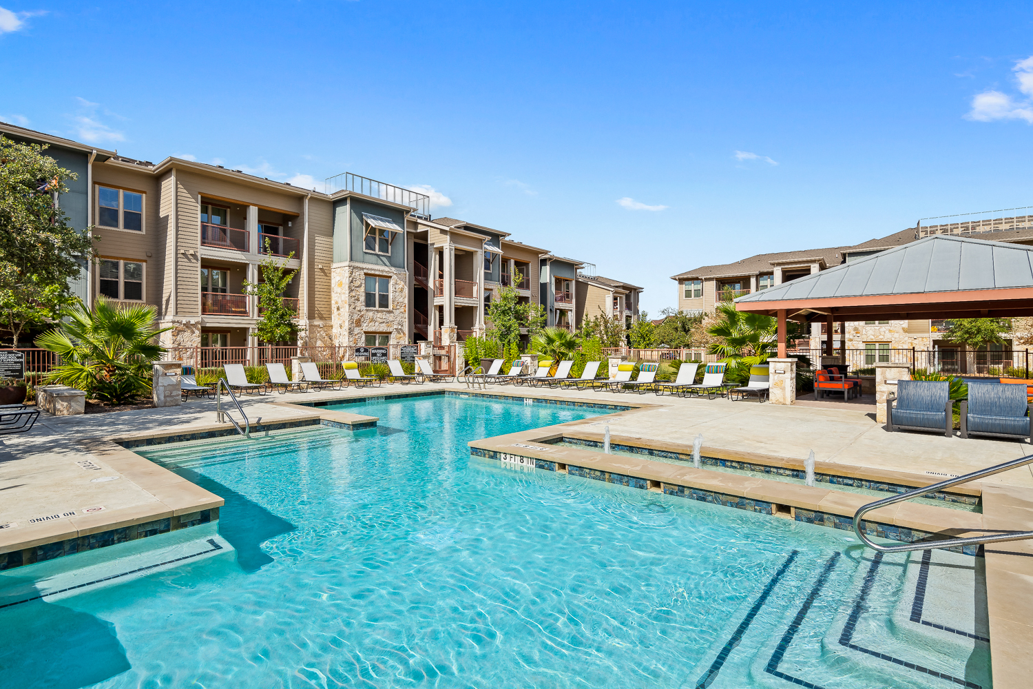 a swimming pool with an apartment building in the background