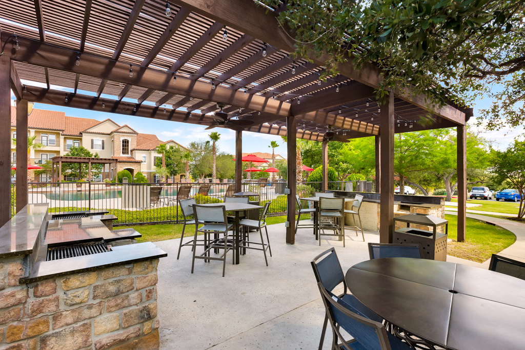 a patio with tables and chairs and a pergola