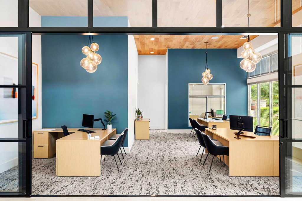 a large office with desks and chairs and a blue wall