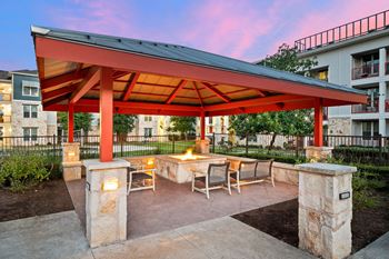 a patio with a fire pit and a red pavilion