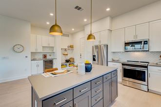 a large kitchen with white cabinets and stainless steel appliances