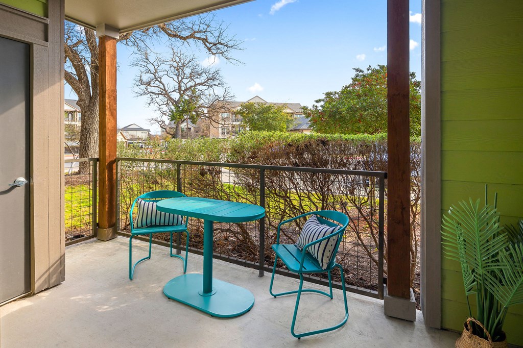 patio with beautiful view of oak trees and. teal table and chairs for relaxing.