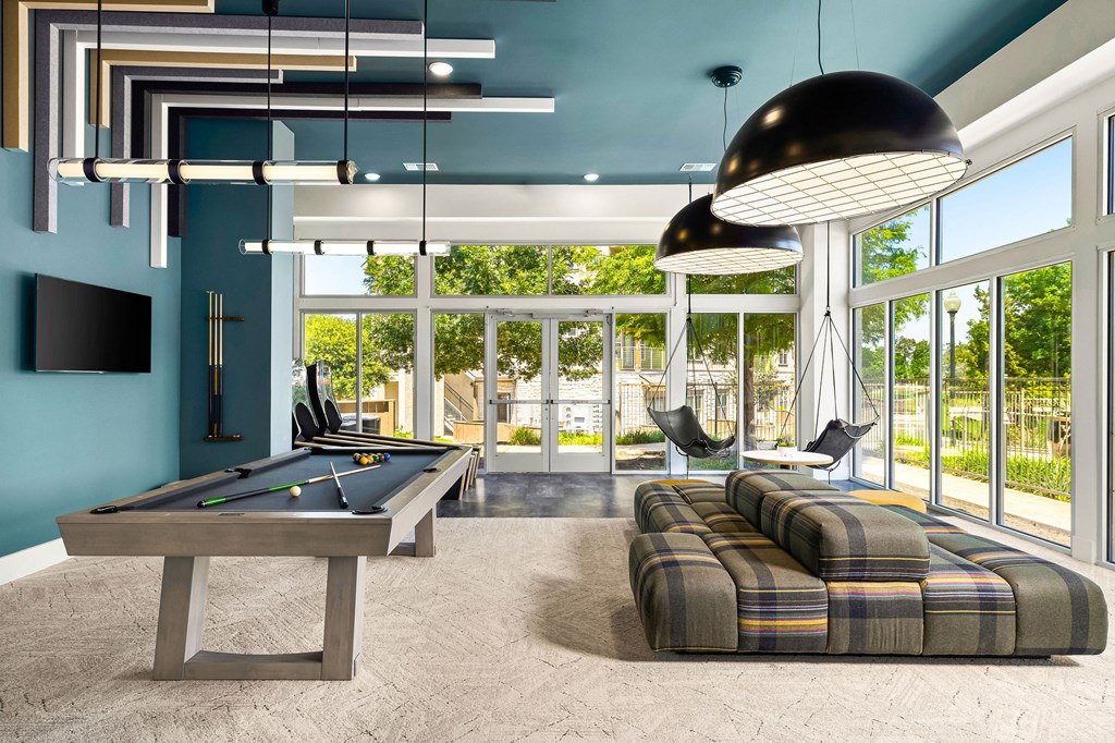 a billiards room with a pool table and couches
