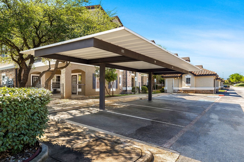 a covered parking lot with a building in the background