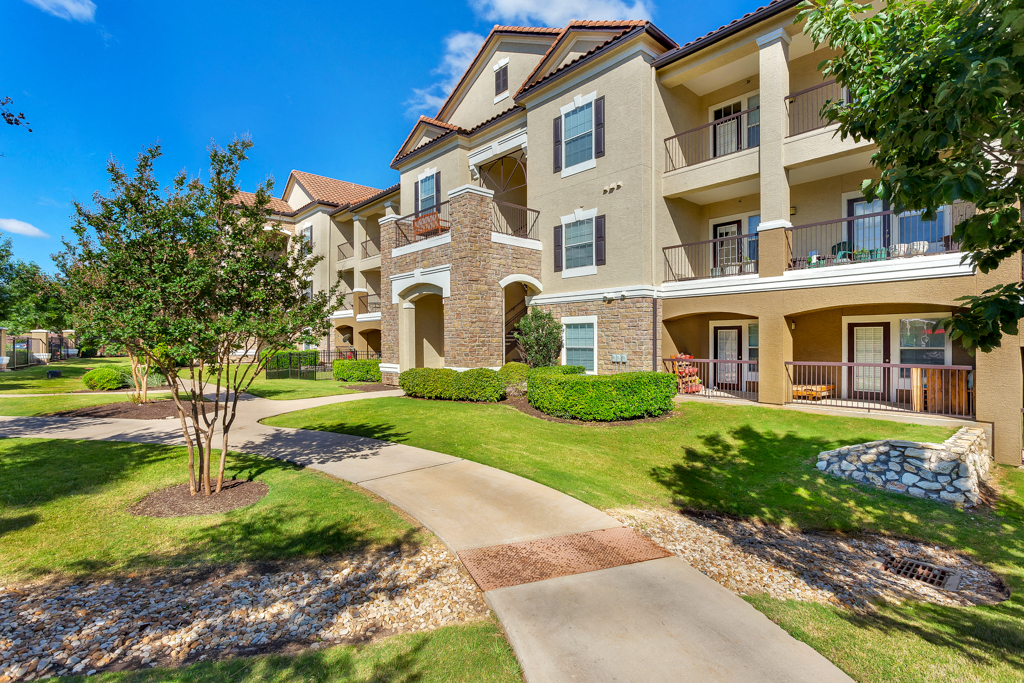 a walkway in front of an apartment building
