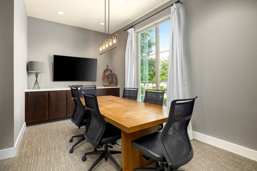 a conference room with a wooden table and chairs and a tv