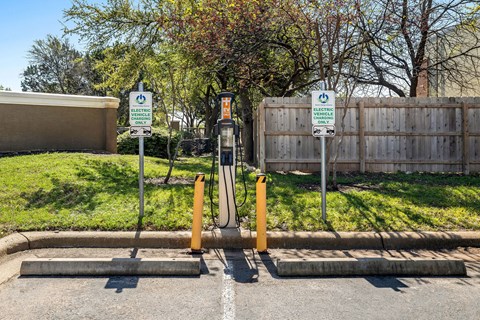 a gas station in a parking lot in front of a fence