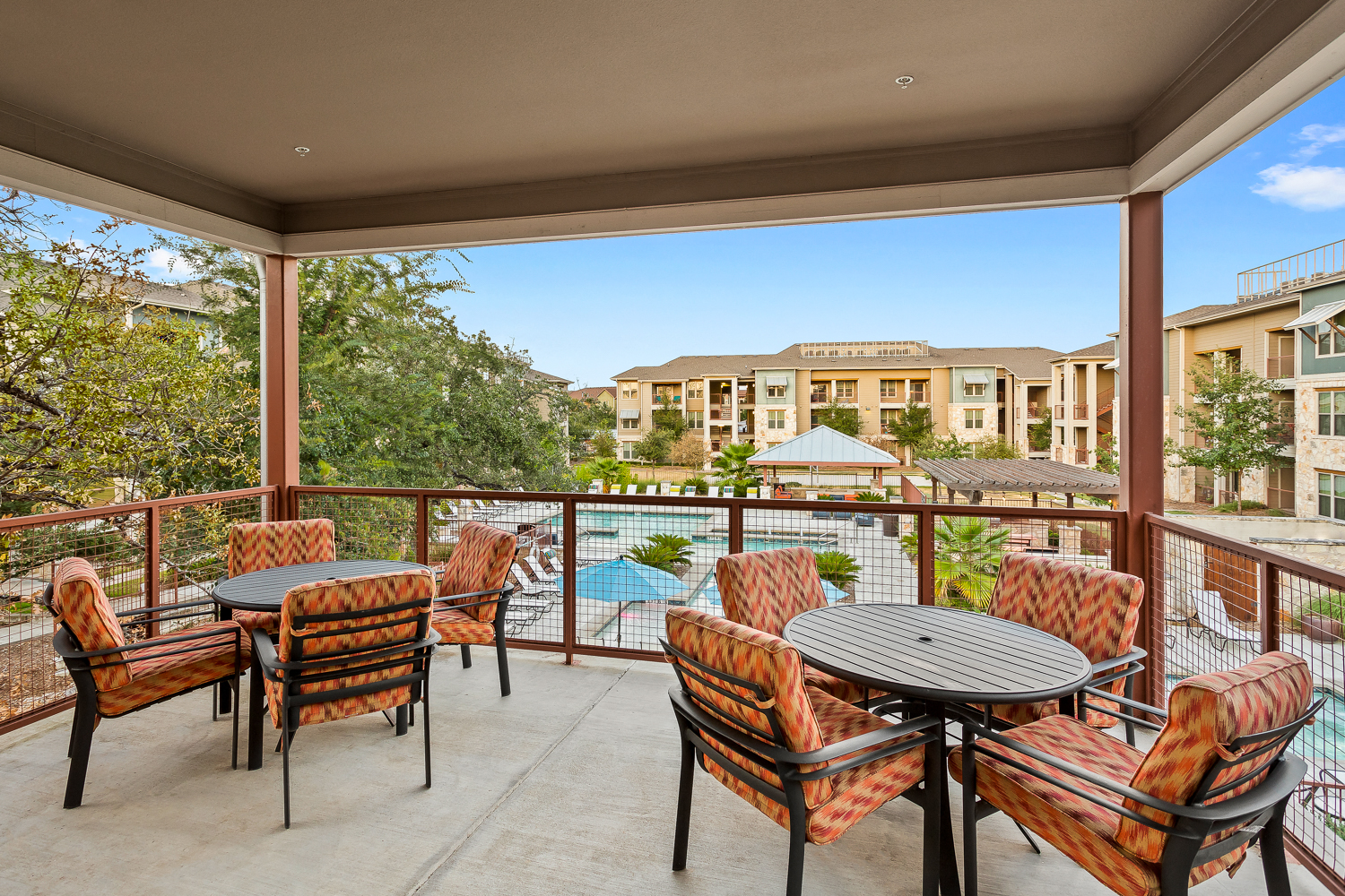 a patio with tables and chairs and a swimming pool