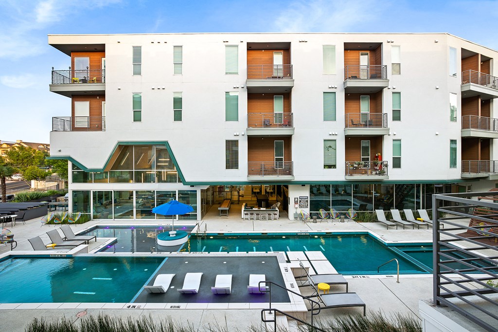 a hotel with a swimming pool and a building with balconies