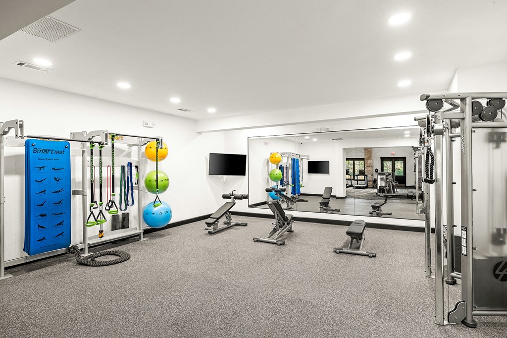 a gym with cardio equipment and weights in a large space