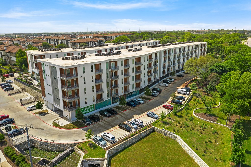 a view of a large building from above with a parking lot