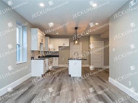 a large kitchen with white cabinets and a sink