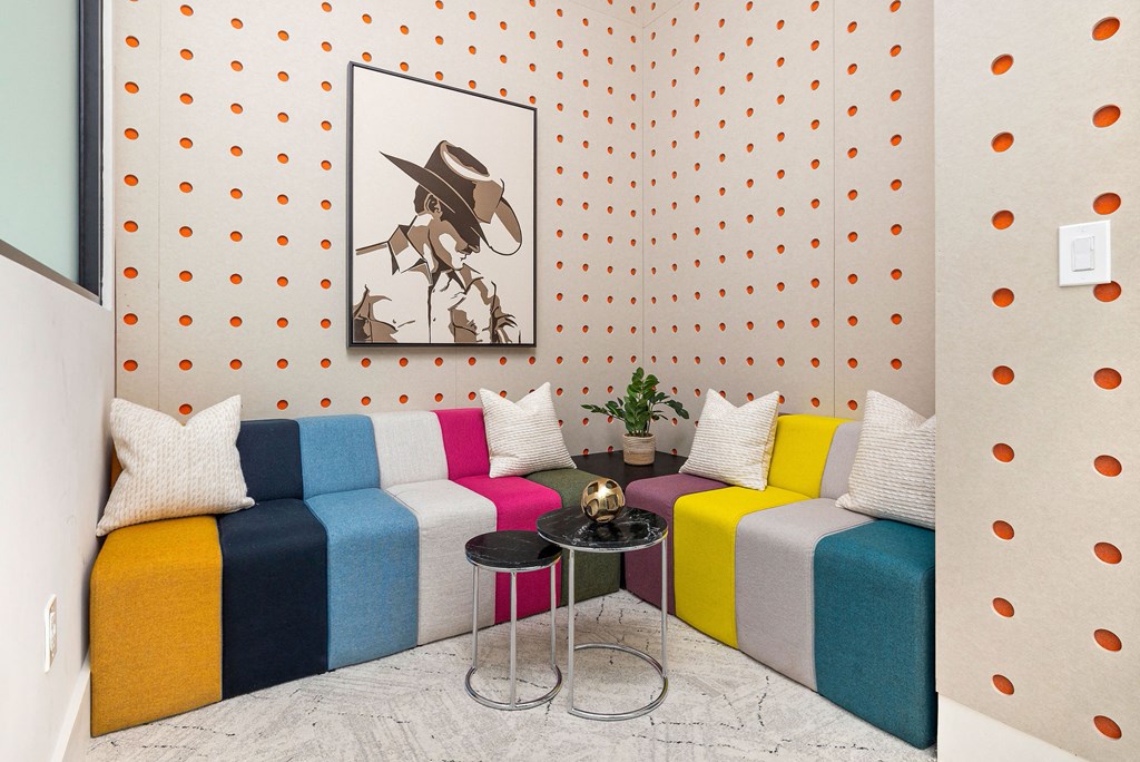 a living room with colorful couches and a painting on the wall