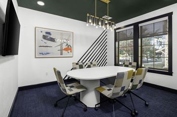 a conference room with a white table and chairs