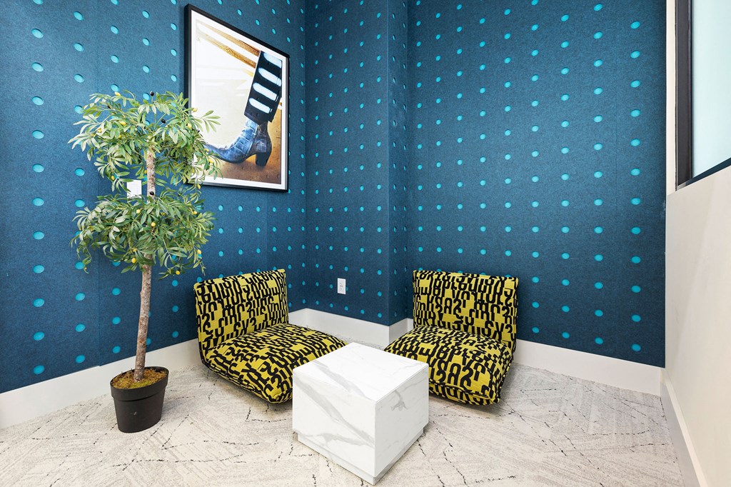 two chairs and a table in a room with a plant