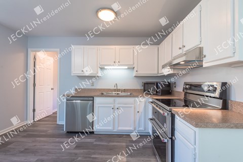 A modern kitchen with white cabinets and stainless steel appliances.