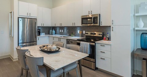 A modern kitchen with a dining table and chairs.