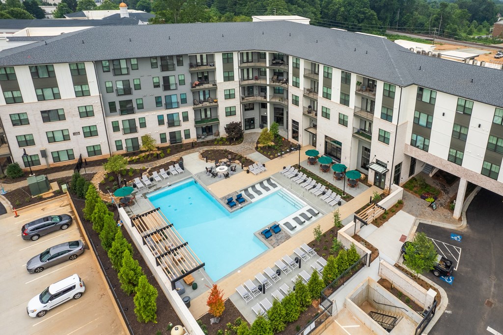 an aerial view of a large swimming pool in front of a building